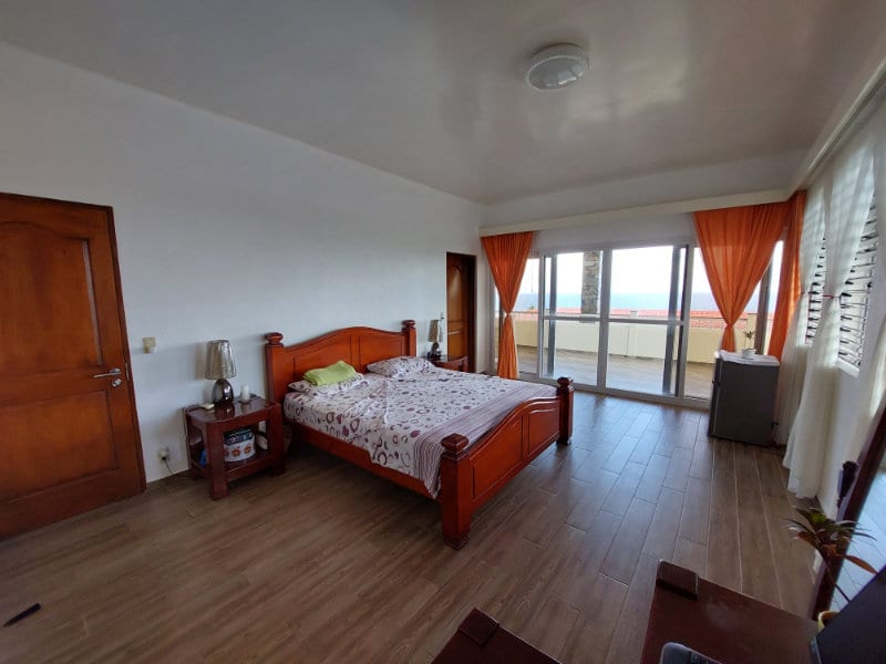 Bedroom with view of pool and sea